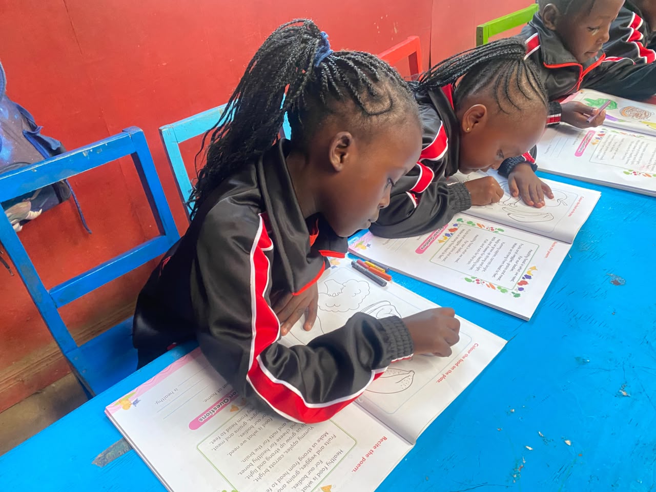 Happy learners raising their hands at St. Genevieve Academy